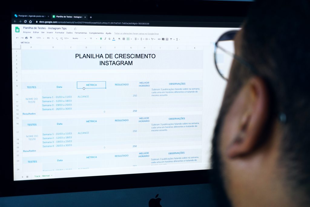 Homem olhando tela do computador aberta em uma planilha de dados