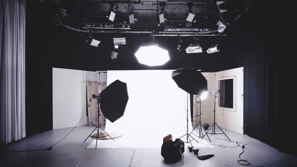 na imagem contém um estúdio de fotografia com luzes e outros equipamentos para captura de fotos profissionais.