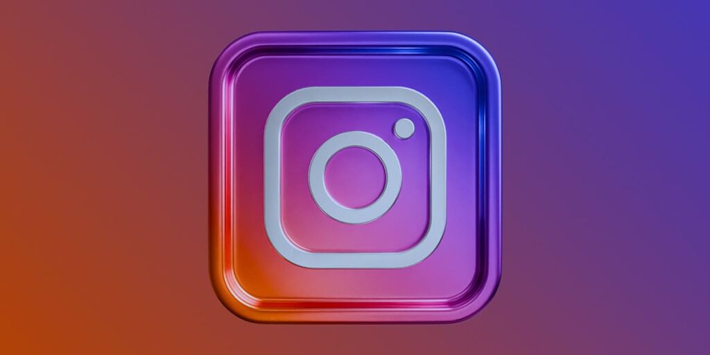 Mudanças no Instagram - A imagem que ilustra o tema tem o fundo degradê nas cores do Instagram: roxo, rosa, laranja, azul e vermelho. E, no meio, em destaque, tem a logo do Instagram.