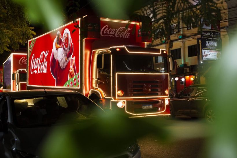 A imagem mostra o caminho da Coca Cola especial de Natal numa via pública.