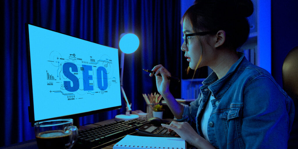 Uma mulher olhando estatísticas de SEO no computador