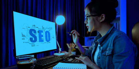 Uma mulher olhando estatísticas de SEO no computador